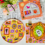 Monster Mash table with a window-cling crayon set, framed-monster print plates, and napkins.