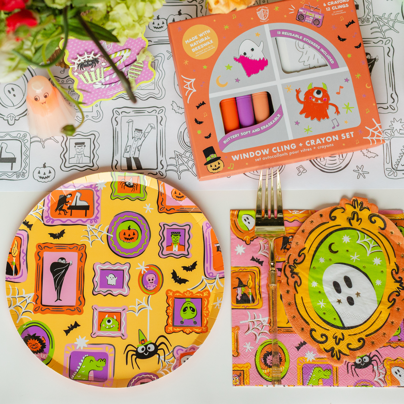 Monster Mash table with a window-cling crayon set, framed-monster print plates, and napkins.